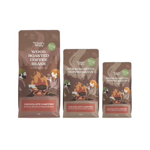 Three bags of Wholey Moley Wood Roasted Coffee Beans in different sizes, featuring a brown and orange campfire illustration on a white background.