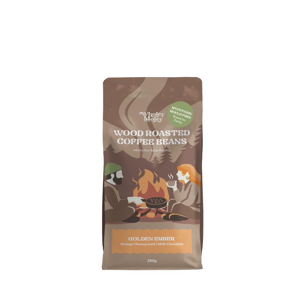 A 250g bag of Wholey Moley Wood Roasted Coffee Beans in the Golden Ember flavor, featuring a brown packaging design with an illustration of two people camping by a fire.